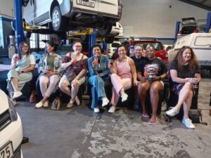 9 Women drinking champaign with cars in the background